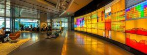 a sleek, modern office meeting room features a large digital display showcasing vibrant data analytics and communication metrics, with a team of diverse professionals engaged in a dynamic discussion about optimizing their digital marketing strategies.
